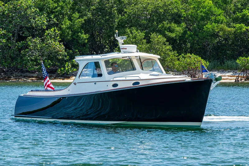 Summer Bliss Yacht Photos Pics 2001 Hinckley Picnic Boat Classic cruising on a serene waterway, surrounded by lush greenery.