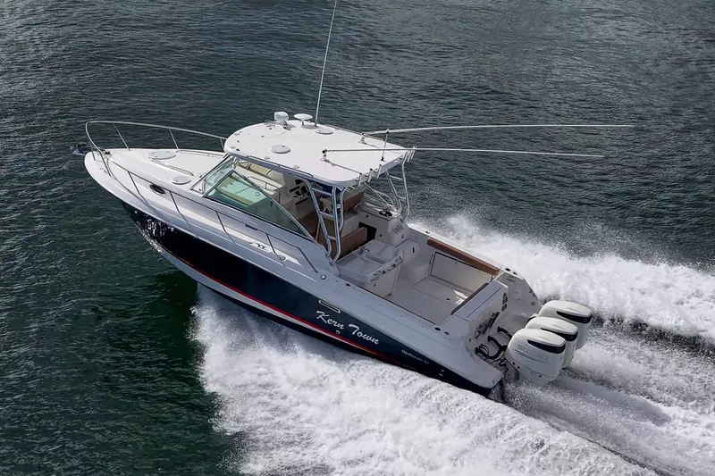  Yacht Photos Pics 2013 Wellcraft 340 Coastal boat cruising on water with triple outboard engines.