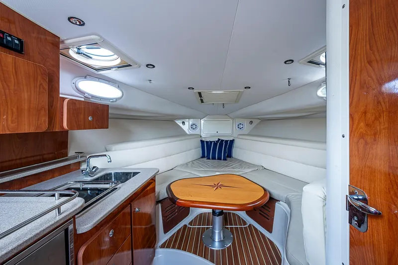  Yacht Photos Pics 2013 Wellcraft 340 Coastal cabin interior with kitchenette, seating, and wooden accents.