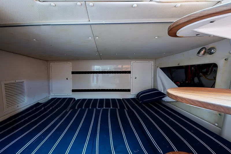 Yacht Photos Pics 2013 Wellcraft 340 Coastal cabin interior with striped bedding and wooden accents.