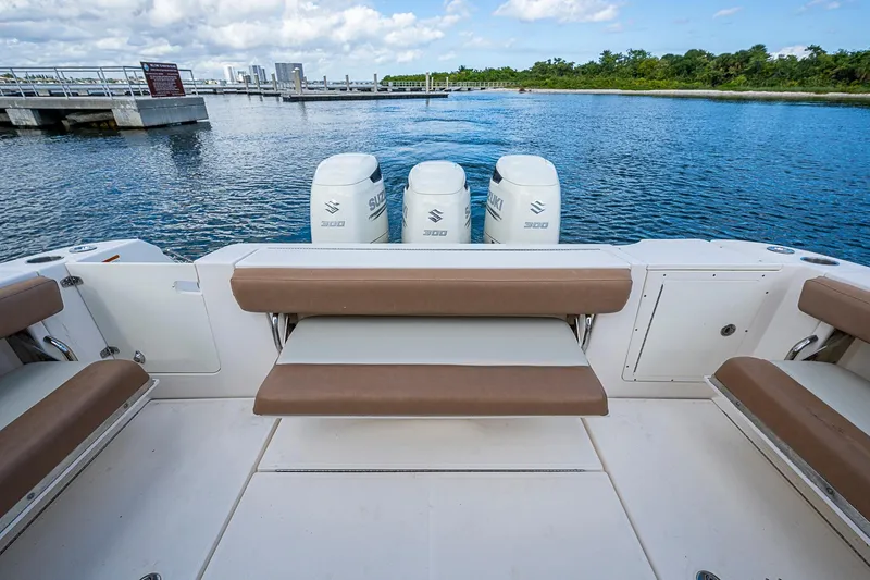  Yacht Photos Pics 2013 Wellcraft 340 Coastal boat with triple Suzuki engines, docked by a scenic waterfront.