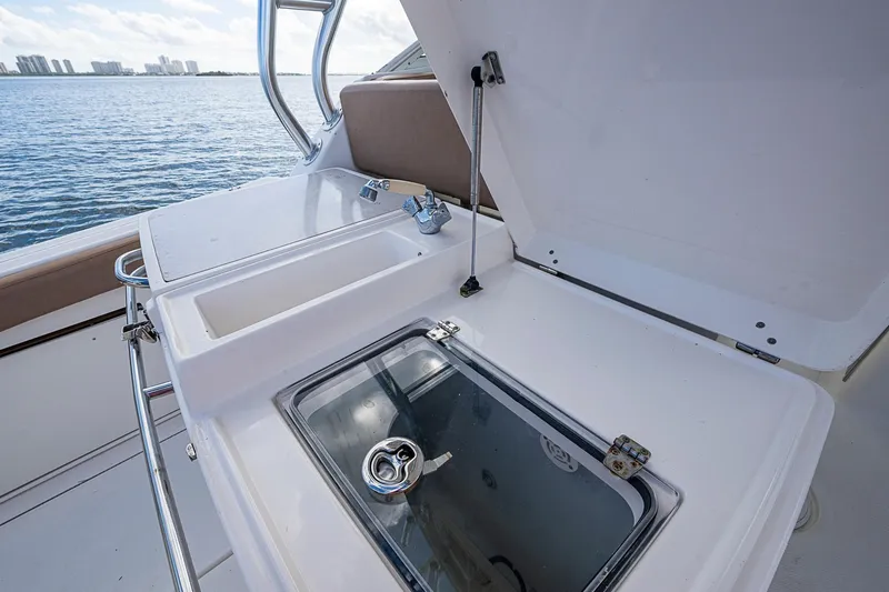  Yacht Photos Pics 2013 Wellcraft 340 Coastal boat with open storage compartment and sink, overlooking water.