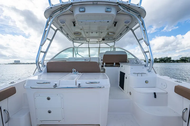  Yacht Photos Pics 2013 Wellcraft 340 Coastal boat interior with seating and storage, under a cloudy sky.