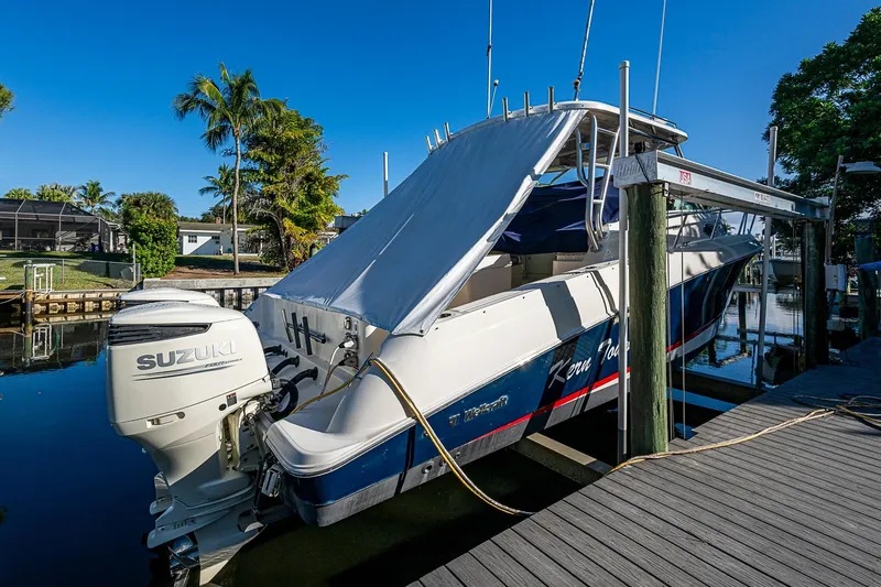  Yacht Photos Pics 2013 Wellcraft 340 Coastal boat docked with Suzuki outboard motor, under clear blue sky.