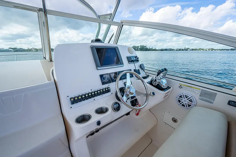  Yacht Photos Pics 2013 Wellcraft 340 Coastal boat helm with steering wheel and navigation controls.