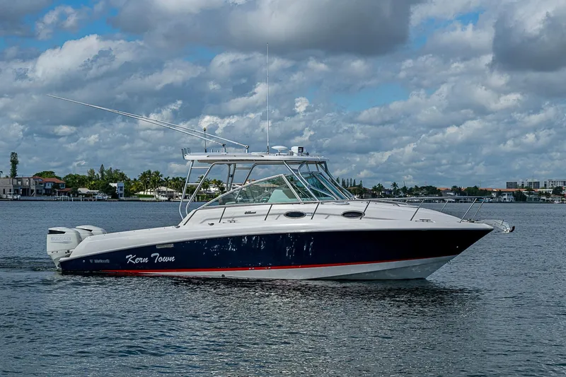  Yacht Photos Pics 2013 Wellcraft 340 Coastal boat cruising on a calm waterway under a cloudy sky.
