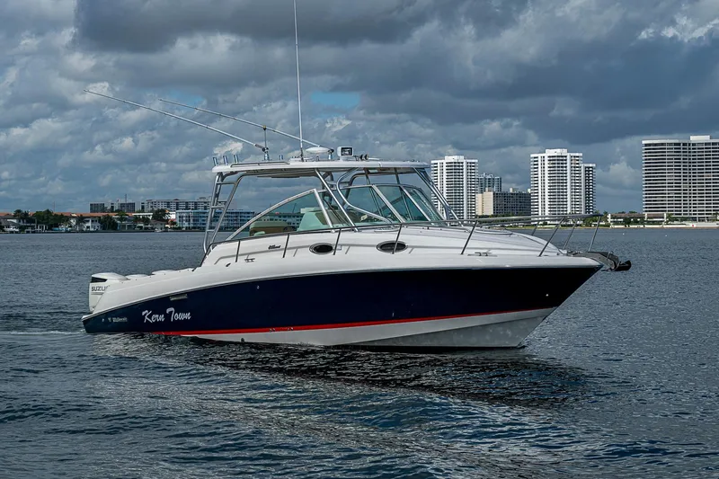 Yacht Photos Pics 2013 Wellcraft 340 Coastal boat cruising on water with city skyline backdrop.