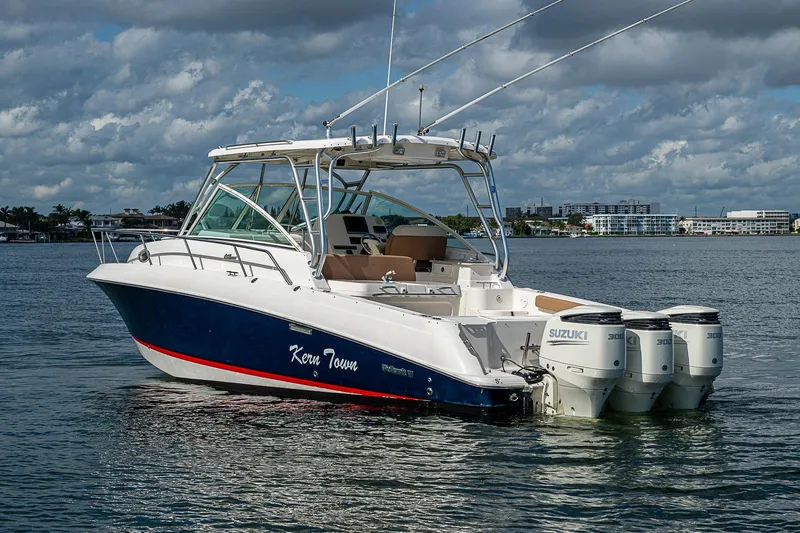  Yacht Photos Pics 2013 Wellcraft 340 Coastal boat with triple Suzuki engines on calm water.