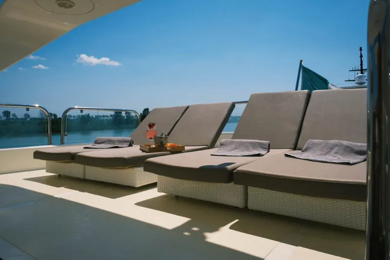  Yacht Photos Pics Luxurious sun loungers on 2004 Astondoa 82 GLX yacht deck, under clear blue sky.