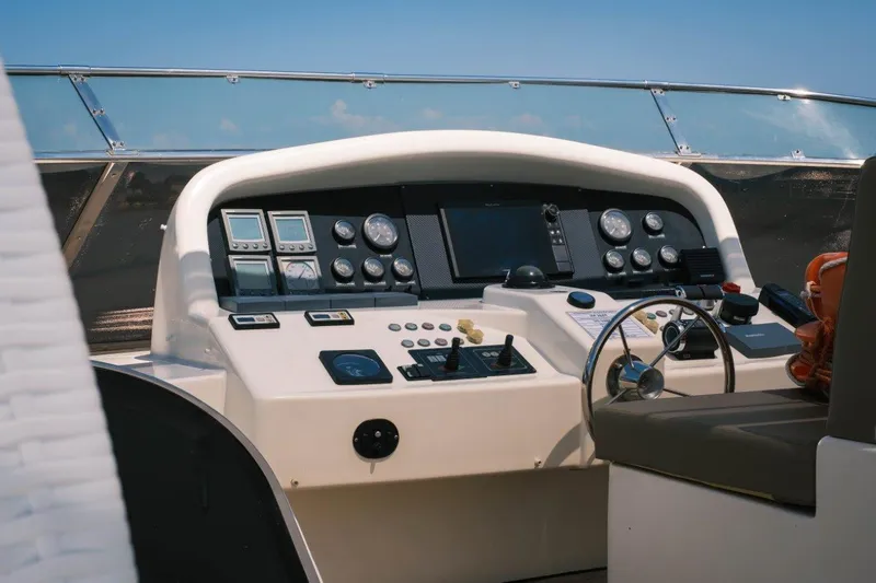  Yacht Photos Pics Control panel of 2004 Astondoa 82 GLX yacht with navigation instruments and steering wheel.
