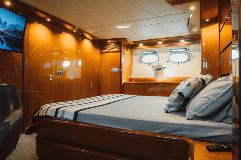  Yacht Photos Pics Luxurious bedroom interior of 2004 Astondoa 82 GLX yacht with elegant wood finish.