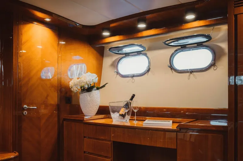  Yacht Photos Pics Luxurious interior of 2004 Astondoa 82 GLX yacht with wood finish and porthole windows.