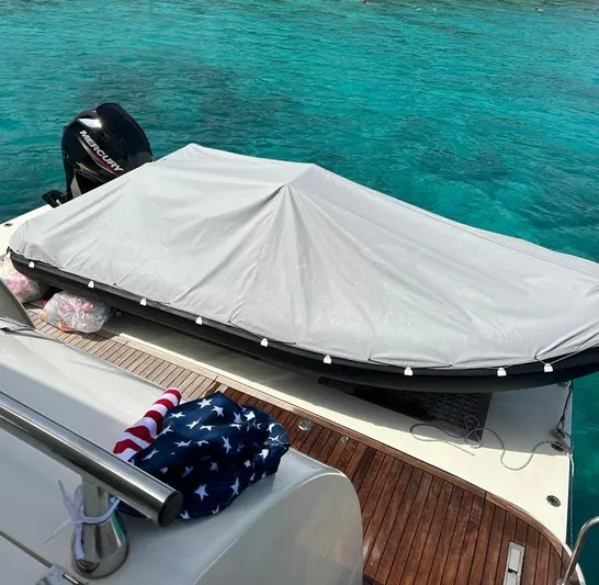  Yacht Photos Pics Astondoa 82 GLX yacht deck with covered equipment, American flag, and turquoise water.