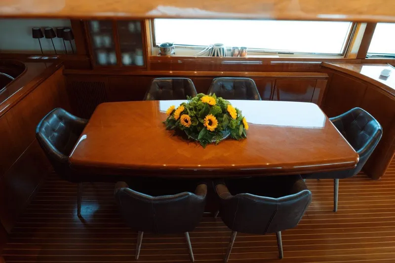  Yacht Photos Pics Luxurious dining area on 2004 Astondoa 82 GLX yacht with elegant table and sunflowers.