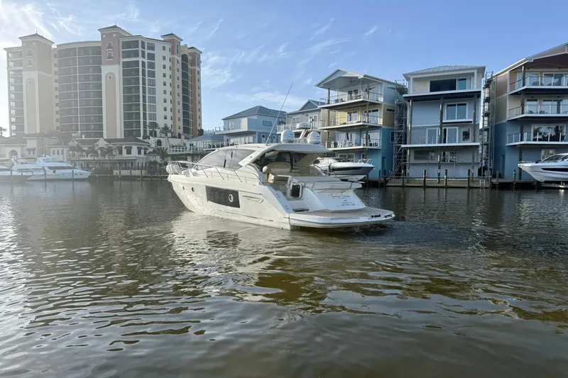Tom's Cruise Yacht Photos Pics 2016 Cranchi M 44 HT yacht on calm water near modern waterfront buildings.