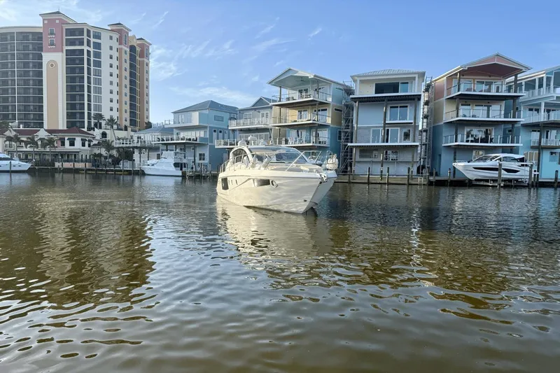 Tom's Cruise Yacht Photos Pics 2016 Cranchi M 44 HT yacht in a marina with modern waterfront buildings.