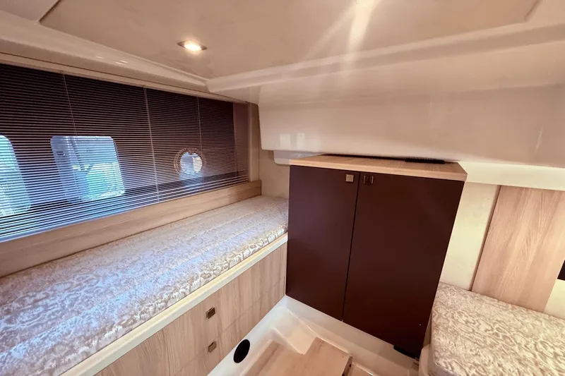 Tom's Cruise Yacht Photos Pics Interior cabin of 2016 Cranchi M 44 HT yacht with cozy bedding and wooden cabinetry.