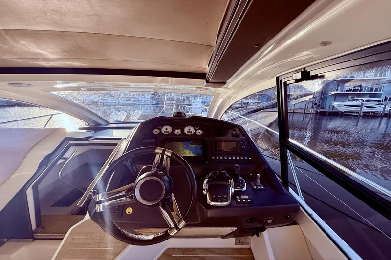 Tom's Cruise Yacht Photos Pics Interior view of 2016 Cranchi M 44 HT yacht cockpit with steering wheel and control panel.