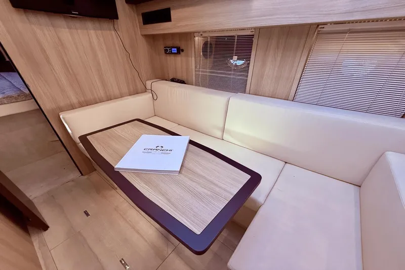 Tom's Cruise Yacht Photos Pics Interior of 2016 Cranchi M 44 HT yacht with beige seating and wooden table.