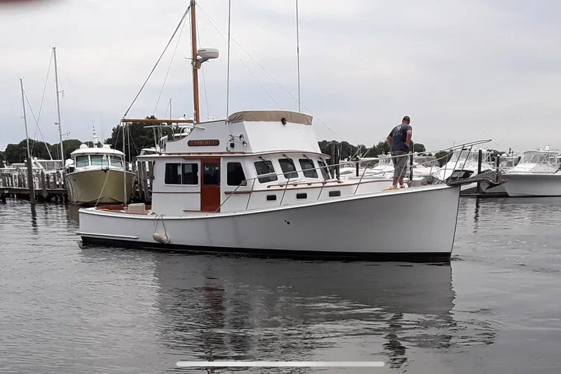 Carroll L Yacht Photos Pics A 2001 Lowell 40 boat docked in a marina with a person on deck.