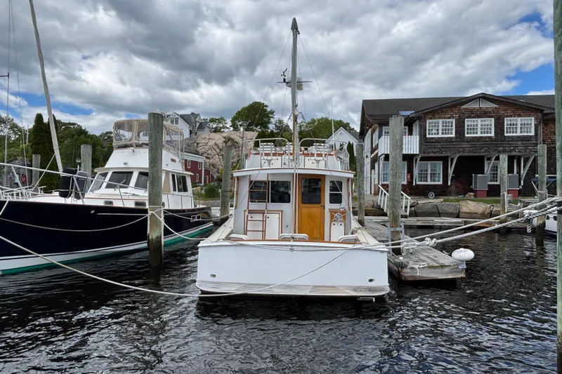 Carroll L Yacht Photos Pics Docked Lowell 40 boat from 2001 at a marina with rustic buildings and cloudy sky.