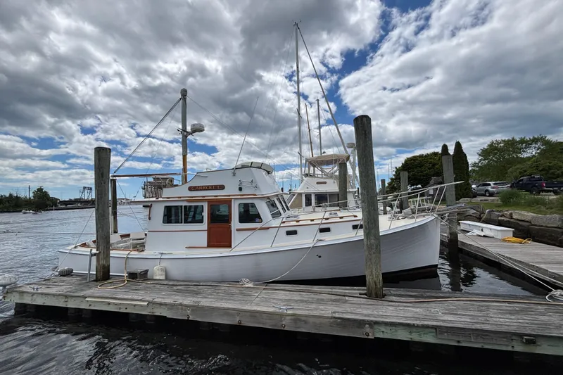 Carroll L Yacht Photos Pics White Lowell 40 boat docked at a marina under a cloudy sky, 2001 model.