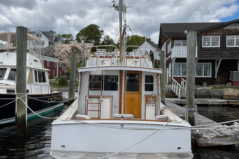 Carroll L Yacht Photos Pics Front view of a 2001 Lowell 40 boat docked at a marina with cloudy skies.