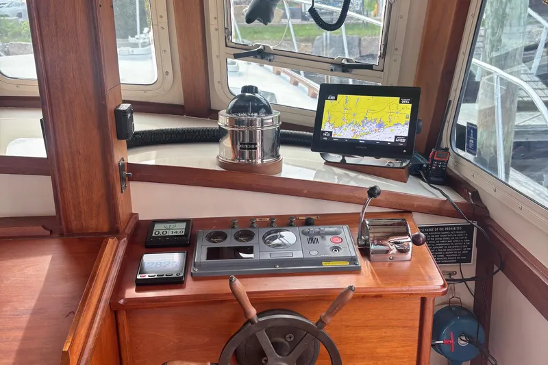 Carroll L Yacht Photos Pics Boat cockpit with navigation equipment, wooden dashboard, and steering wheel on a 2001 Lowell 40.