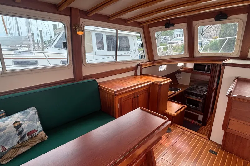 Carroll L Yacht Photos Pics Interior of 2001 Lowell 40 boat with wooden furnishings and green seating.