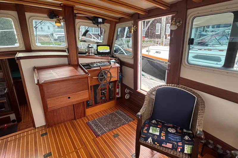 Carroll L Yacht Photos Pics Interior of a 2001 Lowell 40 boat with wooden helm and wicker chair.