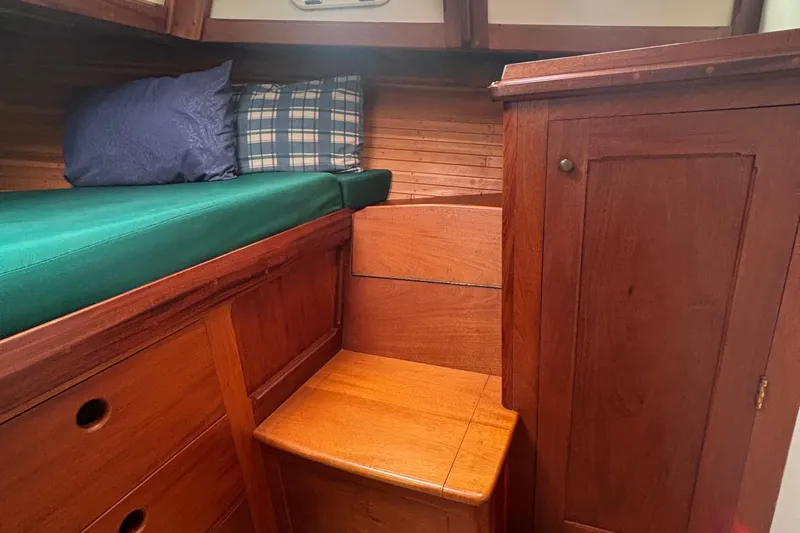 Carroll L Yacht Photos Pics Cozy wooden boat cabin interior with green cushion and pillows, Lowell 40, 2001 model.