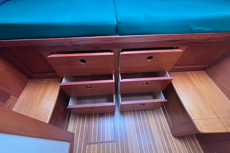 Carroll L Yacht Photos Pics Wooden drawers under teal cushion in Lowell 40, 2001 model boat interior.