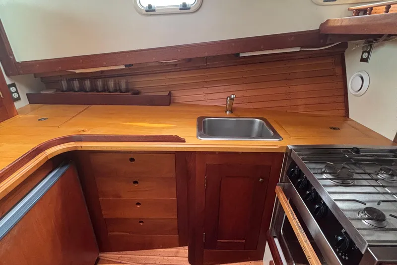Carroll L Yacht Photos Pics Wooden boat kitchen interior with sink, stove, and storage. Lowell 40, 2001 model.