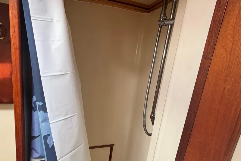Carroll L Yacht Photos Pics Shower area in a 2001 Lowell 40 boat with wooden accents and curtain.