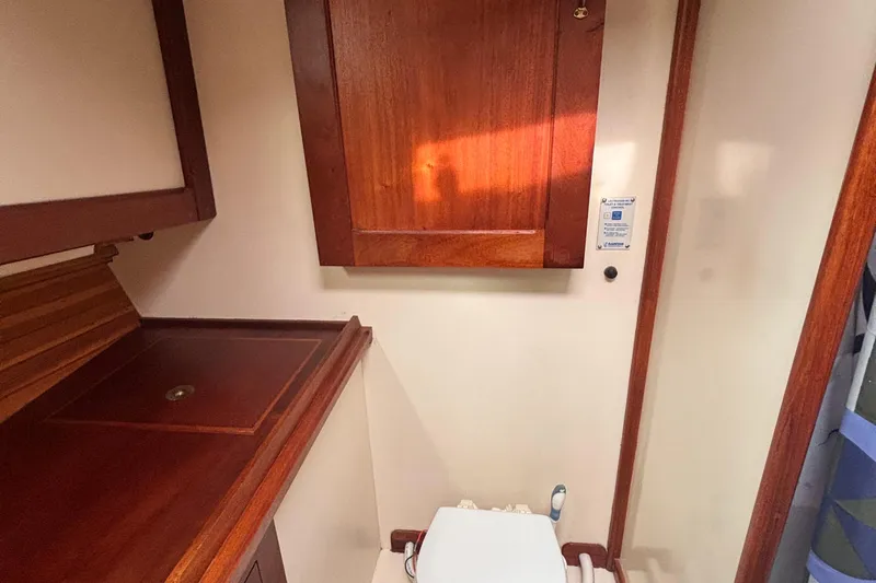Carroll L Yacht Photos Pics Wood-paneled bathroom interior of a 2001 Lowell 40 boat, featuring a compact toilet.