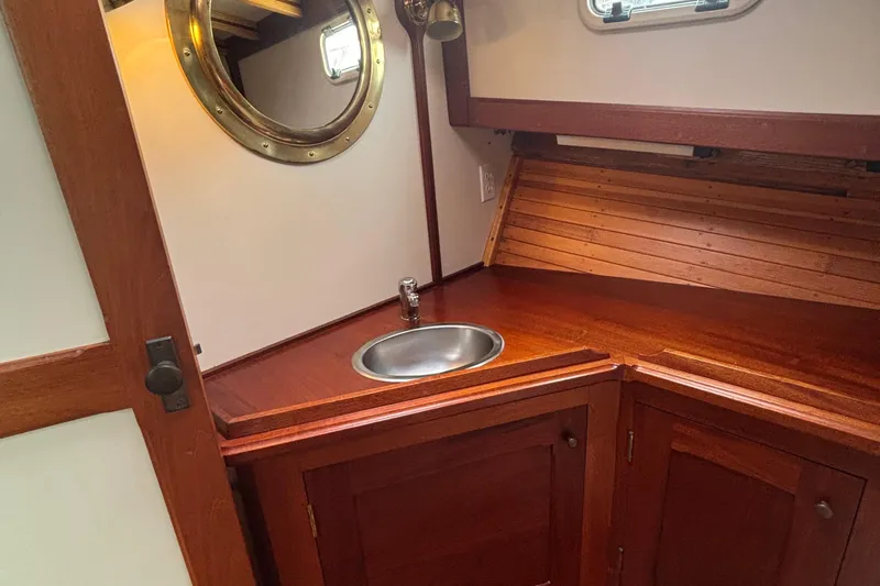 Carroll L Yacht Photos Pics Wooden boat interior with sink, porthole, and cabinetry, Lowell 40, 2001 model.