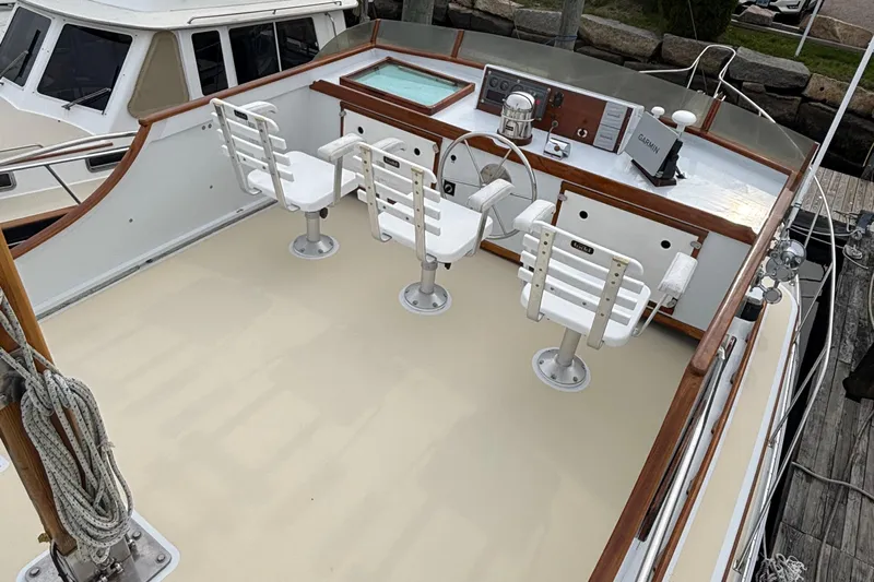 Carroll L Yacht Photos Pics Open deck of a 2001 Lowell 40 boat with three white chairs and navigation equipment.