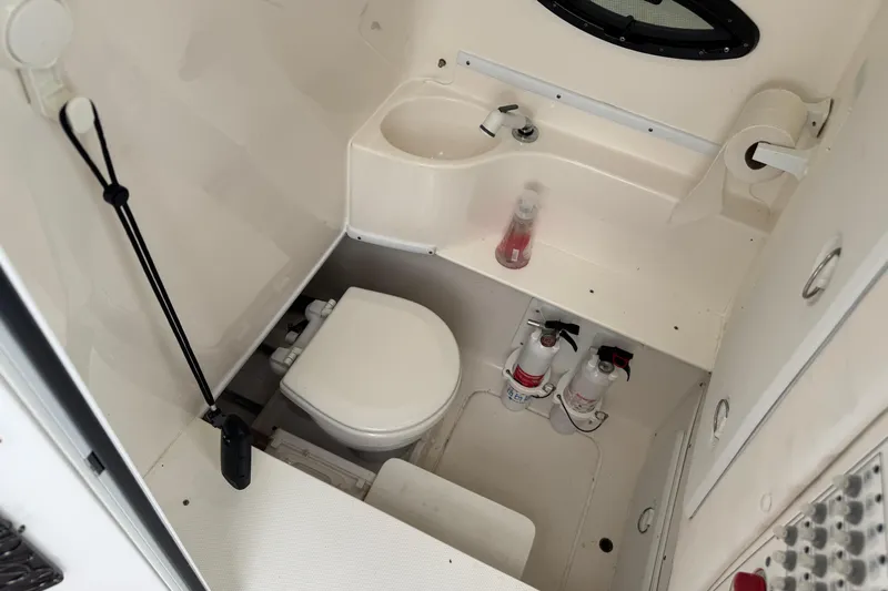  Yacht Photos Pics 2024 Contender 30 Tournament boat bathroom with toilet, sink, and fire extinguishers.