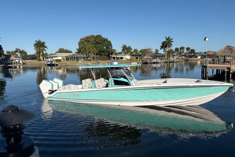  Yacht Photos Pics 2024 Nor-Tech 390 Sport Center Console boat on calm water, surrounded by palm trees.