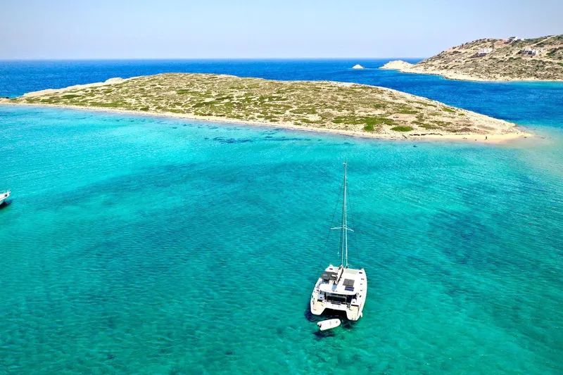 Keyma Yacht Photos Pics Lagoon 42 catamaran anchored in turquoise waters near a small island, 2020 model.