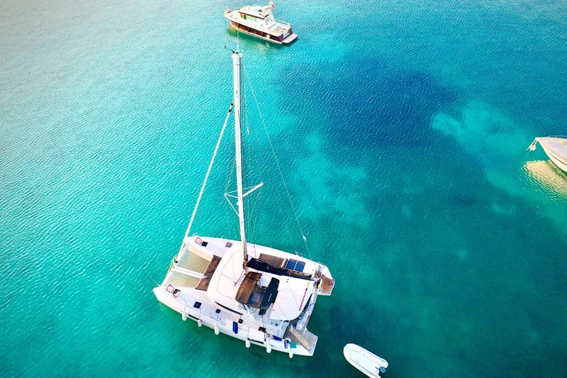 Keyma Yacht Photos Pics Aerial view of 2020 Lagoon 42 catamaran on clear turquoise water.