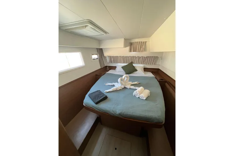 Keyma Yacht Photos Pics Luxurious cabin interior of 2020 Lagoon 42 yacht with neatly arranged bed and towels.