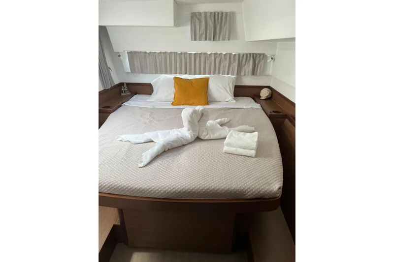 Keyma Yacht Photos Pics Luxurious cabin interior of 2020 Lagoon 42 yacht with neatly arranged bed and towels.