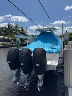Reel Craft Yacht Photos Pics 2024 SeaVee 340Z boat with blue cover and triple outboard motors docked by palm trees.