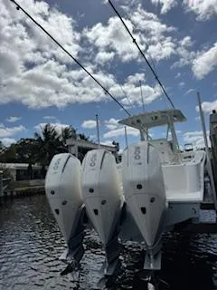 Reel Craft Yacht Photos Pics 2024 SeaVee 340Z boat with triple outboard engines, docked under a partly cloudy sky.