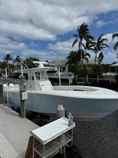 Reel Craft Yacht Photos Pics 2024 SeaVee 340Z boat docked by palm trees under a partly cloudy sky.