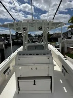 Reel Craft Yacht Photos Pics 2024 SeaVee 340Z boat with center console and fishing rod holders, docked under a cloudy sky.
