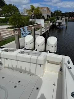 Reel Craft Yacht Photos Pics 2024 SeaVee 340Z boat docked with triple outboard engines, in a scenic waterfront setting.