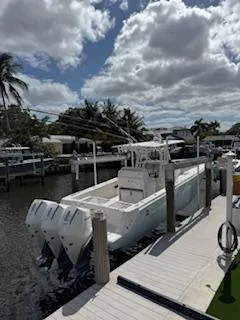 Reel Craft Yacht Photos Pics 2024 SeaVee 340Z boat docked, featuring triple outboard engines under a partly cloudy sky.
