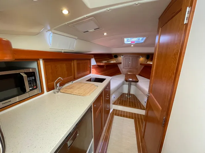Corsair Yacht Photos Pics 2020 MJM 35z yacht interior with modern kitchen, wood cabinetry, and cozy seating area.